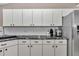 Clean kitchen features white cabinets, dark countertops, and stainless steel refrigerator at 4085 Ne 17Th Ave, Ocala, FL 34479