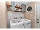 Functional laundry room with white subway tile, overhead cabinets, and modern washer and dryer at 4085 Ne 17Th Ave, Ocala, FL 34479