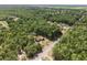 High-altitude aerial shot displays the neighborhood with the house nestled among lush trees at 4467 Sw Channel Heights Ct, Dunnellon, FL 34431
