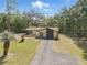 Aerial view of a single-story house, featuring a long drive at 4467 Sw Channel Heights Ct, Dunnellon, FL 34431