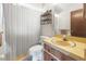 Bathroom featuring tile flooring, vanity, sink, mirror, decorative shelving, and white shower curtain at 4467 Sw Channel Heights Ct, Dunnellon, FL 34431