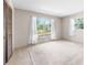 Bright bedroom featuring neutral walls, carpet, large windows, sheer white curtains and wood slat closet doors at 4467 Sw Channel Heights Ct, Dunnellon, FL 34431