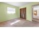 Bedroom featuring pastel green walls, carpet, windows with blinds and wood slat closet doors at 4467 Sw Channel Heights Ct, Dunnellon, FL 34431