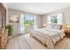 Bedroom with neutral walls, carpet, large windows, sheer curtains, and bed with nightstands at 4467 Sw Channel Heights Ct, Dunnellon, FL 34431