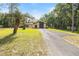 View of a home with a cracked driveway with a palm tree on a grassy front yard at 4467 Sw Channel Heights Ct, Dunnellon, FL 34431