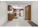 Functional kitchen featuring wood cabinets, white appliances, and tile flooring at 4467 Sw Channel Heights Ct, Dunnellon, FL 34431