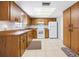 Functional kitchen featuring wood cabinets, white appliances, and tile flooring at 4467 Sw Channel Heights Ct, Dunnellon, FL 34431