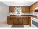 Kitchen featuring wood cabinets, white appliances, tile flooring and a view from the window at 4467 Sw Channel Heights Ct, Dunnellon, FL 34431