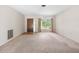 Empty living room showing carpet, front door, and a window with natural lighting at 4467 Sw Channel Heights Ct, Dunnellon, FL 34431