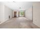 Empty living room showing carpet, front door, and a window with natural lighting at 4467 Sw Channel Heights Ct, Dunnellon, FL 34431