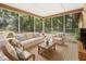 Screened patio with tile flooring and outdoor seating featuring decorative pillows at 4467 Sw Channel Heights Ct, Dunnellon, FL 34431