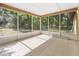 Screened patio with tile flooring surrounded by screens and greenery at 4467 Sw Channel Heights Ct, Dunnellon, FL 34431