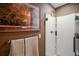 Modern bathroom showcasing a clean white shower, towel racks, and a framed picture, offering a refreshing design at 4673 Se 115Th St, Belleview, FL 34420