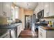 Galley kitchen boasts stainless appliances, granite counters and white cabinets at 4673 Se 115Th St, Belleview, FL 34420