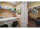Well-lit laundry room with modern appliances and a wire rack for storage with an open doorway to living area at 4673 Se 115Th St, Belleview, FL 34420