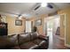 Spacious living room with a comfortable leather sofa, ceiling fans, and hardwood floors leading to other rooms at 4673 Se 115Th St, Belleview, FL 34420