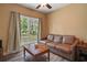 Living room features a brown leather sofa, wood floors, and a large window overlooking the yard at 4673 Se 115Th St, Belleview, FL 34420