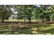 Spacious yard with mature trees and a charming home visible through the trees at 4673 Se 115Th St, Belleview, FL 34420