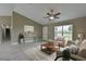 Cozy living room features modern furnishings, a ceiling fan, neutral color palette, and view of the neighborhood at 490 Marion Oaks Golf Way, Ocala, FL 34473