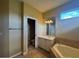 Bright bathroom featuring a soaking tub, neutral tile, and single sink vanity at 4940 Sw 63Rd Loop, Ocala, FL 34474