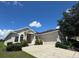 Well maintained one story home featuring a low-pitched roof, arched windows, and a manicured lawn at 4940 Sw 63Rd Loop, Ocala, FL 34474