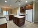 Spacious kitchen featuring an island, tile floor, and dark cabinets with modern appliances at 4940 Sw 63Rd Loop, Ocala, FL 34474