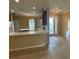 Open kitchen with an island, tile floor, and modern countertops adjacent to a dining area at 4940 Sw 63Rd Loop, Ocala, FL 34474