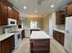 Open kitchen with an island, tile floor, and dark cabinets with modern appliances at 4940 Sw 63Rd Loop, Ocala, FL 34474