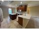 Open kitchen with an island, tile floor, and dark cabinets with modern appliances at 4940 Sw 63Rd Loop, Ocala, FL 34474