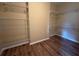 Empty walk-in closet featuring built-in shelving and wood laminate flooring at 4940 Sw 63Rd Loop, Ocala, FL 34474