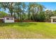 View of large grassy fenced backyard, home and small shed at 5005 Ne 22Nd Ave, Ocala, FL 34479