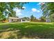 Large, grassy, fenced backyard with house, covered porch and firepit at 5005 Ne 22Nd Ave, Ocala, FL 34479