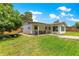 Wide shot of house, covered back porch, and spacious, fenced backyard at 5005 Ne 22Nd Ave, Ocala, FL 34479