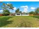 Wide angle view of the grassy fenced backyard and home at 5005 Ne 22Nd Ave, Ocala, FL 34479