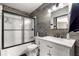 Bathroom featuring wood accent wall, a glass shower door, and marbled vanity at 5005 Ne 22Nd Ave, Ocala, FL 34479