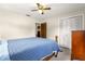 Bedroom featuring carpeted floors, ceiling fan, a cozy bed and closet with white doors at 5005 Ne 22Nd Ave, Ocala, FL 34479