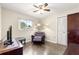 Cozy bedroom featuring hardwood floors, a ceiling fan, and a comfortable reading nook with a recliner at 5005 Ne 22Nd Ave, Ocala, FL 34479