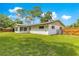 Beautiful home exterior with a white facade, large windows, green grass, and a well-maintained wooden fence at 5005 Ne 22Nd Ave, Ocala, FL 34479