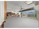 Spacious garage with ample storage, a workbench area, and a door that opens to a view of a neighbor's home at 5005 Ne 22Nd Ave, Ocala, FL 34479