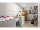Efficient laundry area with appliances, shelving, cabinet, and a utility sink, offering practical convenience at 5005 Ne 22Nd Ave, Ocala, FL 34479