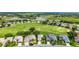 Stunning aerial shot featuring a row of homes, a lush golf course, and a serene pond at 5007 Kelso St, Leesburg, FL 34748