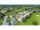High angle aerial showcasing charming homes in a golf community featuring well-manicured lawns and mature trees at 5007 Kelso St, Leesburg, FL 34748