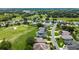 A picturesque aerial view of a golf course community with well-manicured lawns and mature trees at 5007 Kelso St, Leesburg, FL 34748