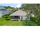 Backyard view of home with screened in porch, lush grass, and meticulous landscaping providing serene outdoor living at 5007 Kelso St, Leesburg, FL 34748