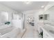 Bright bathroom showcasing vanity with dual sinks, soaking tub, and access to bedroom and shower at 5007 Kelso St, Leesburg, FL 34748