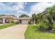 Front exterior showcasing the home's attractive curb appeal with a lush lawn, driveway and meticulously cared-for landscaping at 5007 Kelso St, Leesburg, FL 34748