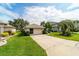 Detached garage with a driveway and well-maintained landscaping in a serene neighborhood setting at 5007 Kelso St, Leesburg, FL 34748