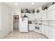Functional kitchen featuring white appliances, tile floors, and a laundry closet at 5007 Kelso St, Leesburg, FL 34748