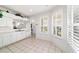 Bright kitchen with tile floors, white cabinetry, and a sunlit breakfast nook at 5007 Kelso St, Leesburg, FL 34748