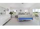 Bright main bedroom with white furniture, a blue comforter, and natural light at 5007 Kelso St, Leesburg, FL 34748